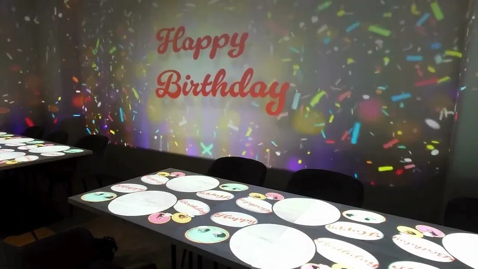壁とテーブルに誕生日の映像を投影したYAKINIKU 37 west NYの店内